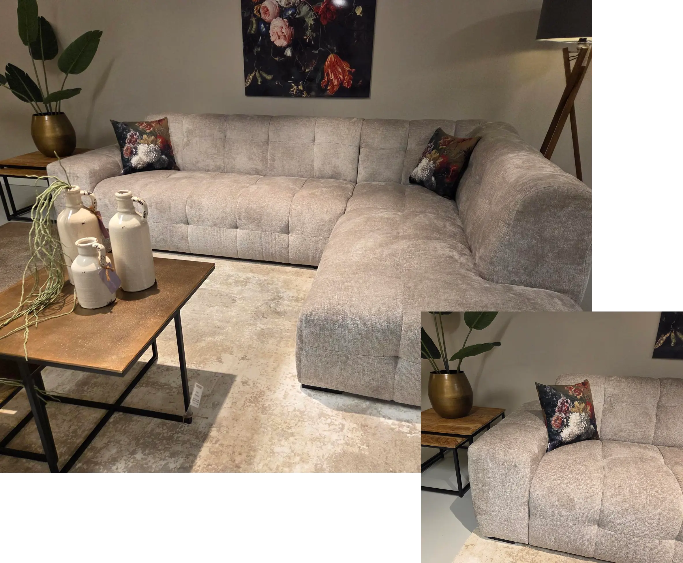 In een moderne woonkamer staat een ruime, grijze hoekbank versierd met kussens met bloemenprint. Op een houten salontafel staan witte vazen